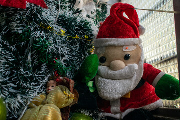 Obraz premium A festive Christmas scene featuring a decorated tree with ornaments, a shining star, plush toys, Santa Claus figurines, and a cozy fireplace. This image captures the warmth and joy of holiday