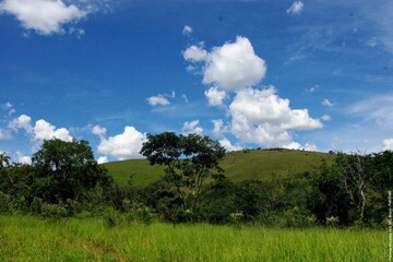 Lush green landscape with rolling hills and cloudy sky
