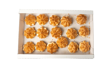 Box with baked goods on a transparent background. The pastries are small, round, laid out in a neat row.