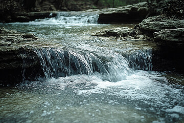 Obraz premium Cascading Water Flows Over Rocks In A Creek