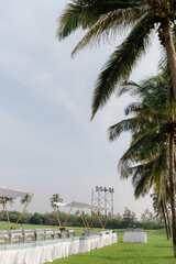 A romantic white beach wedding celebration with an outdoor ceremony, featuring elegant decor, a bottle for colored sand rituals, and a beautifully arranged table under the open sky