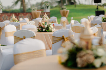 A romantic white beach wedding celebration with an outdoor ceremony, featuring elegant decor, a bottle for colored sand rituals, and a beautifully arranged table under the open sky