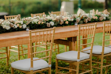 A romantic white beach wedding celebration with an outdoor ceremony, featuring elegant decor, a bottle for colored sand rituals, and a beautifully arranged table under the open sky