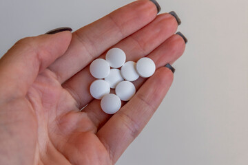 Woman hand holding pills or tablets. Concept of medicals, drug store, pharmacy, healthcare and medicine.