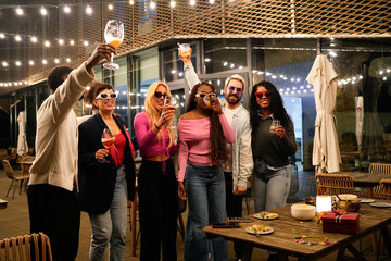 Multiethnic friends enjoying drinks at rooftop party