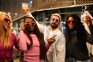 Multiethnic friends enjoying drinks at rooftop party