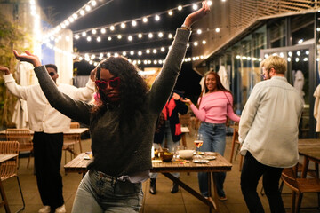 Young multiethnic friends dancing at rooftop party