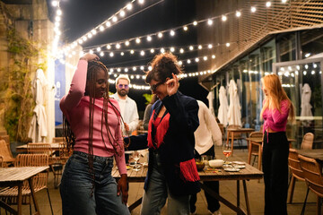 Young multiethnic friends dancing at rooftop party