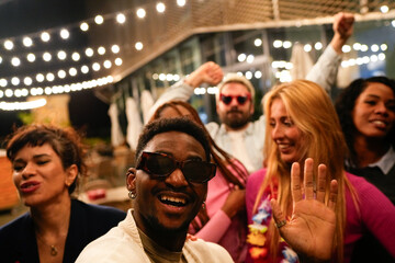 Multiethnic friends enjoying rooftop party, dancing and celebrating