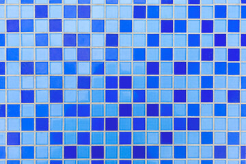 Small square ceramic tiles of blue and azure colors as a background, texture, pattern. Tiles in the pool.