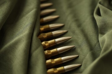 Many rifle bullets on military camo green fabric background