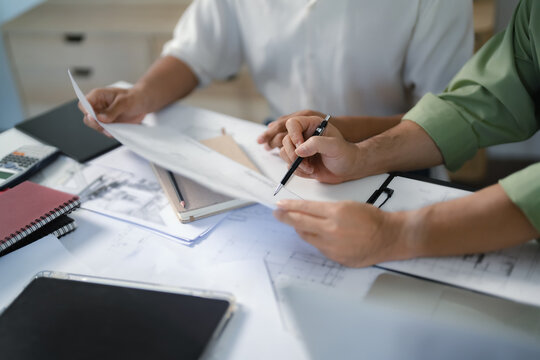 Two engineer businessman talking and brainstorming to planning about blueprint