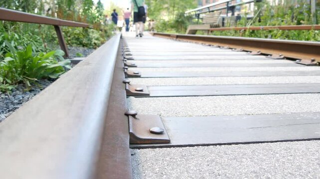 New York City High Line elevated greenway, Manhattan Midtown, USA. People in urban public park. Promenade in garden greenery. American street life, Chelsea highline near Hudson Yards. Railway tracks.