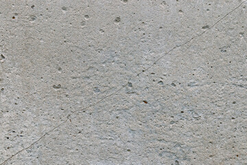 a gray concrete wall cracked diagonally. texture background, close-up