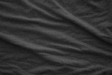 Texture of Dark grey crumpled textile cloth part with small folds