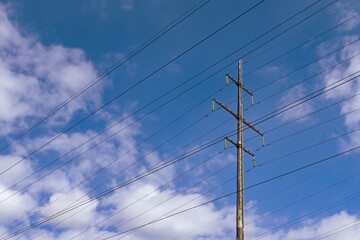 support for a high-voltage power line against the blue sky and sunlight. close up