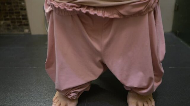 Woman lowering pajama pants to sit on toilet