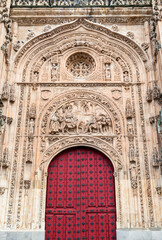 Intricate red door of the historic Cathedral in Salamanca, Spain showcasing detailed carvings