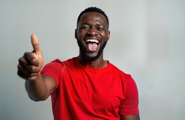 Happy black man shows thumbs up. Cheerful, points aside with finger. Man invites viewer. Recommends product service. Image for business, marketing purposes. Suitable for product presentation.