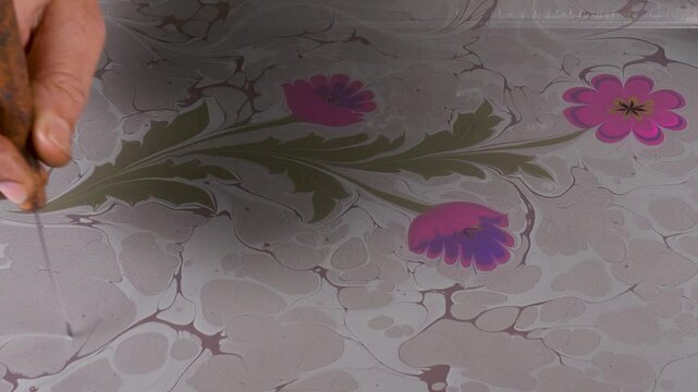 The art of marbling, which is an ornamental art. It is making patterns with paints on water condensed with tragacanth and transferring these patterns onto paper.
