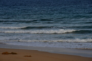 Waves breaking on the yellow sand beach with the freshness of the sea