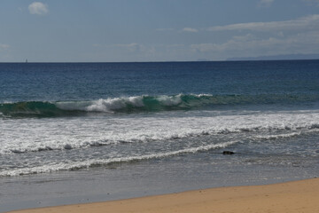 Waves breaking on the yellow sand beach with the freshness of the sea