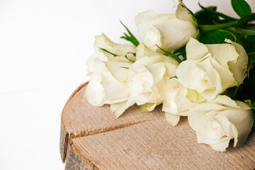 Elegant white roses delicately placed on a rustic wooden plank. The contrast between the soft petals and the textured wood evokes a sense of purity and natural beauty