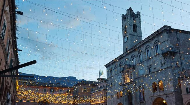  View of Piazza del Popolo in Ascoli Piceno with yellow christmas lights and decorations