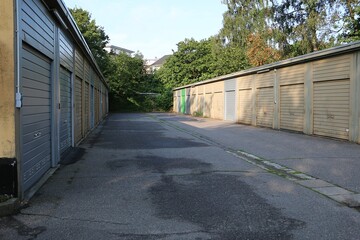 asphalted parking road with garages in a row on the right and left