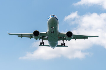 A blue sky background with an airplane prepared for landing on a well known place for plane spotter at Mao Khao Beach, Phuket, Thailand