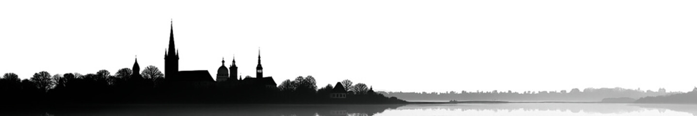 Obraz premium A serene silhouette of a historic church skyline reflected in calm waters at dawn.