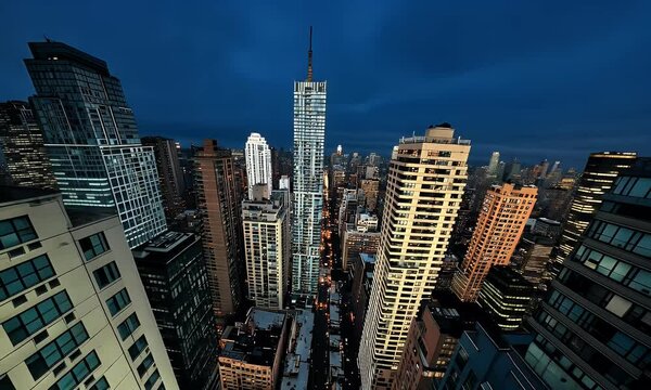 Stunning Aerial View of a Modern City Skyline at Night Featuring Illuminated Skyscrapers Against a Deep Blue Sky