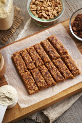 Homemade healthy bars made of whey protein powder, peanut butter, maple syrup and dates