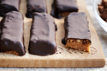 Homemade no-bake healthy bars made of whey protein powder and peanut butter coated in chocolate
