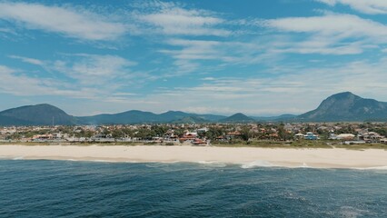 Coastal town with beach and mountains.