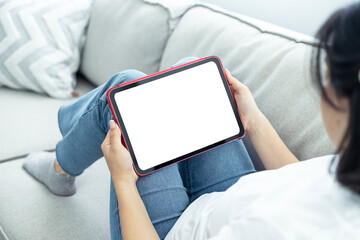 Woman hand holding a tablet blank white screen and sitting on sofa at home