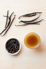 Glass of carajillo, vanilla beans on wood table, top view