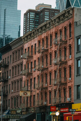 Fototapeta premium Historische Wohngebäude mit Feuertreppen und moderner Skyline im Hintergrund