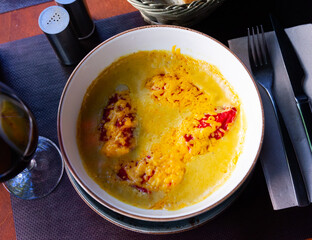 Gratin red bell peppers with filling of codfish under bechamel sauce and cheese