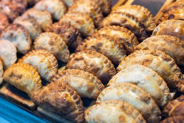 Delicious empanadas lined up in rows in a store window