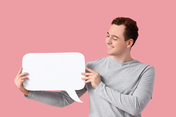 Young man with blank speech bubble on pink background
