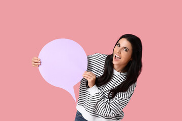 Happy young woman with blank speech bubble on pink background