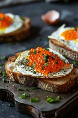 National Caviar Day Sandwiches with red caviar, cheese and egg. Toasted bread with fried egg and red caviar garnished