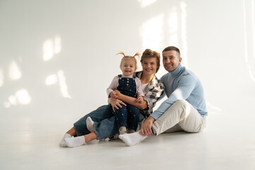 Mom and dad playing with a child on a white background