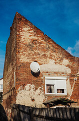 Poor brick house with satelite dish