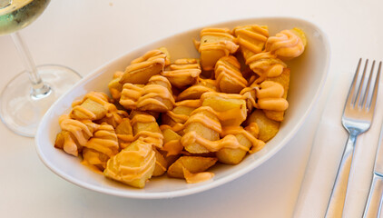 Traditional Spanish potato tapa Patatas bravas with spicy creamy sauce ..