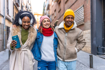 Fototapeta premium Happy multi ethnic friends walking together on a winter city street