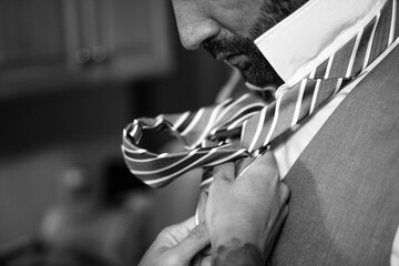 Groom Getting Ready - Close-up of Hands Adjusting Tie on Wedding Day