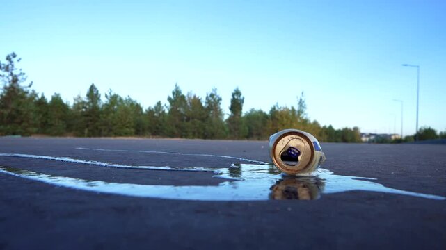 Crumpled soda can on asphalt with drink spilled. Discarded broken carbonated drink tin can on asphalt road. Problem social, crime. Thrown out Crushed juce. Crumpled Beer Can Crushed. Spilled drink.