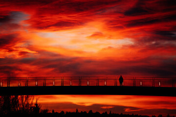 People on bridge at sunset